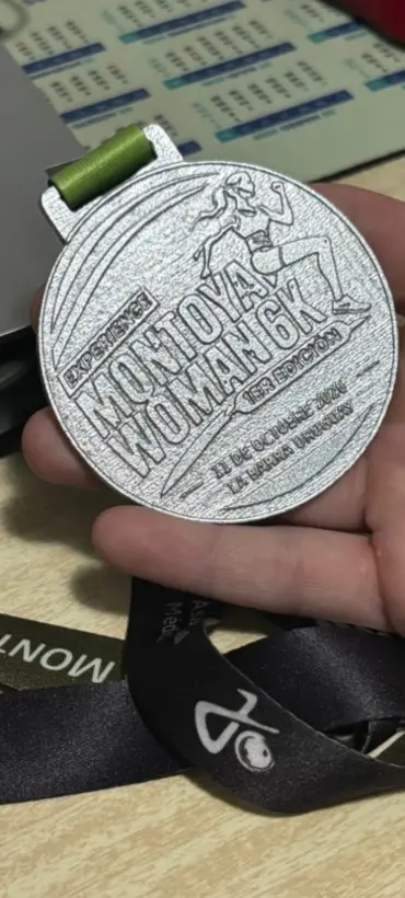 Medalla finisher de Montoya Woman con el logo de Juan Barrios en la cinta